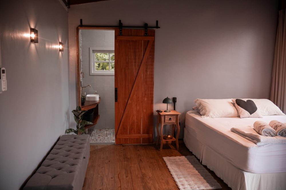 Quarto da Tiny House Herrmann Haus com porta de correr rústica